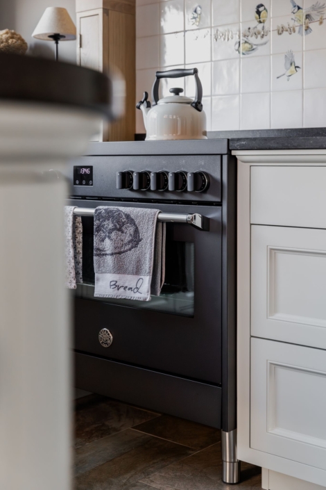 Schoonhoven keukens en interieur: maatwerk keuken. Witte landelijke keuken, ronde kasten en schouw op maat eikenhout