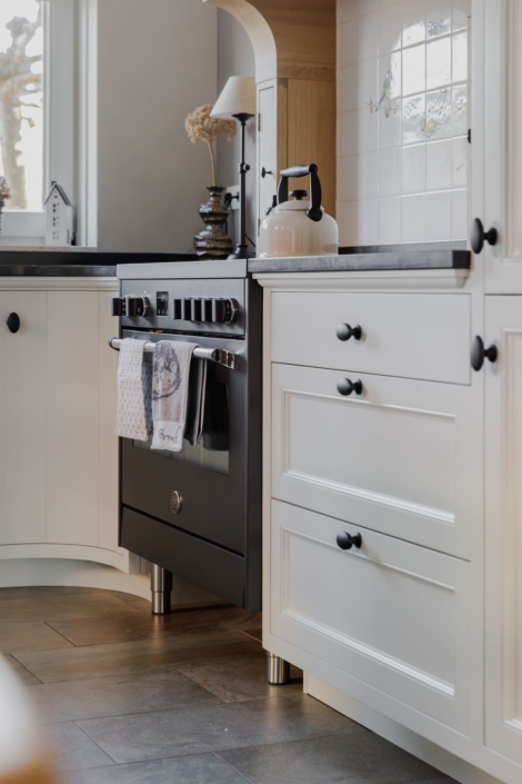 Schoonhoven keukens en interieur: maatwerk keuken. Witte landelijke keuken, ronde kasten en schouw op maat eikenhout