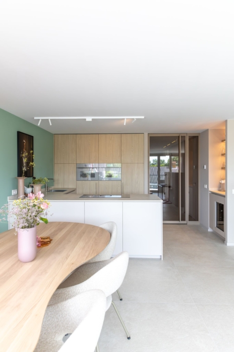 Moderne maatwerkkeuken met greige kookeiland en houtlook kastenwand , Schoonhoven keukens