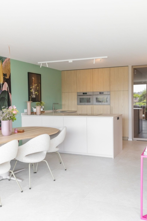 Moderne maatwerkkeuken met greige kookeiland en houtlook kastenwand in Schoonhoven