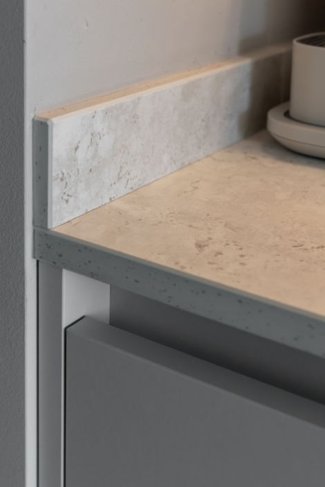 Moderne maatwerkkeuken met greige kookeiland en houtlook kastenwand in Schoonhoven