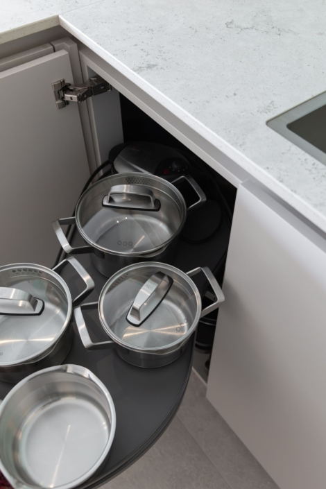 Moderne maatwerkkeuken met greige kookeiland en houtlook kastenwand in Schoonhoven