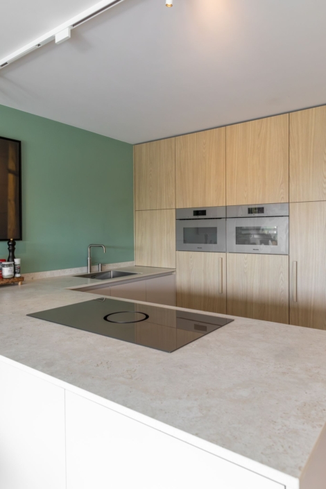 Ingebouwde Miele ovens in beige afgewerkt in houtlook kastenwand maatwerkkeuken